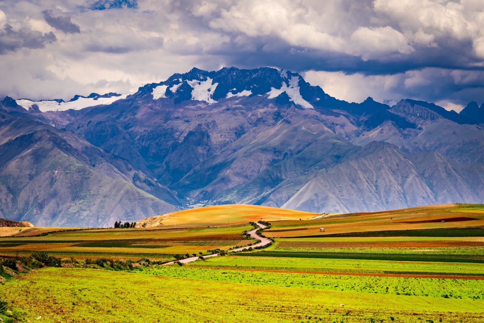 The Sacred Valley of Peru — patchwork fields and a winding road beneath the Andes